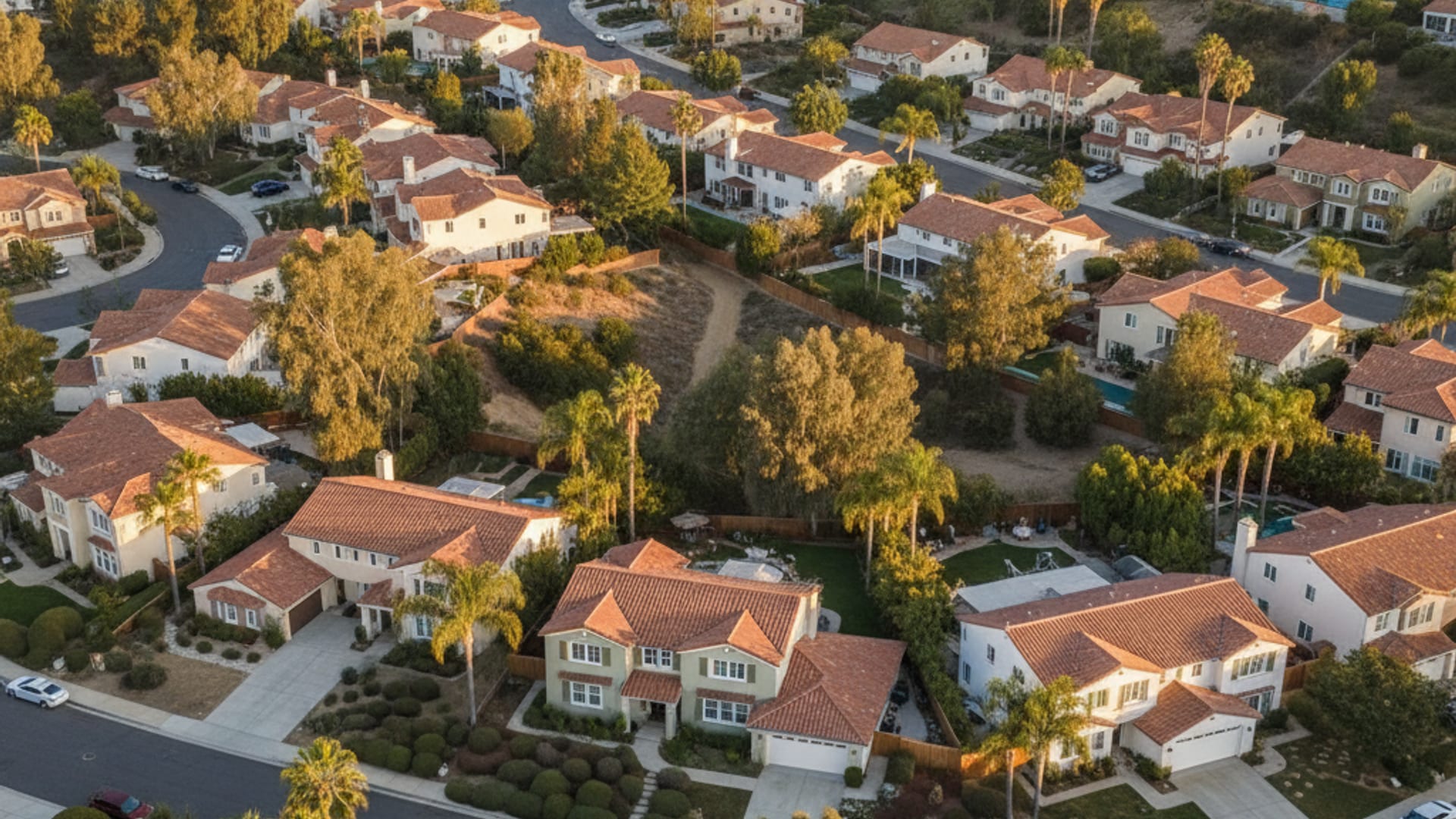 Aerial view of a San Diego County residential neighborhood with freshly painted stucco homes at golden hour